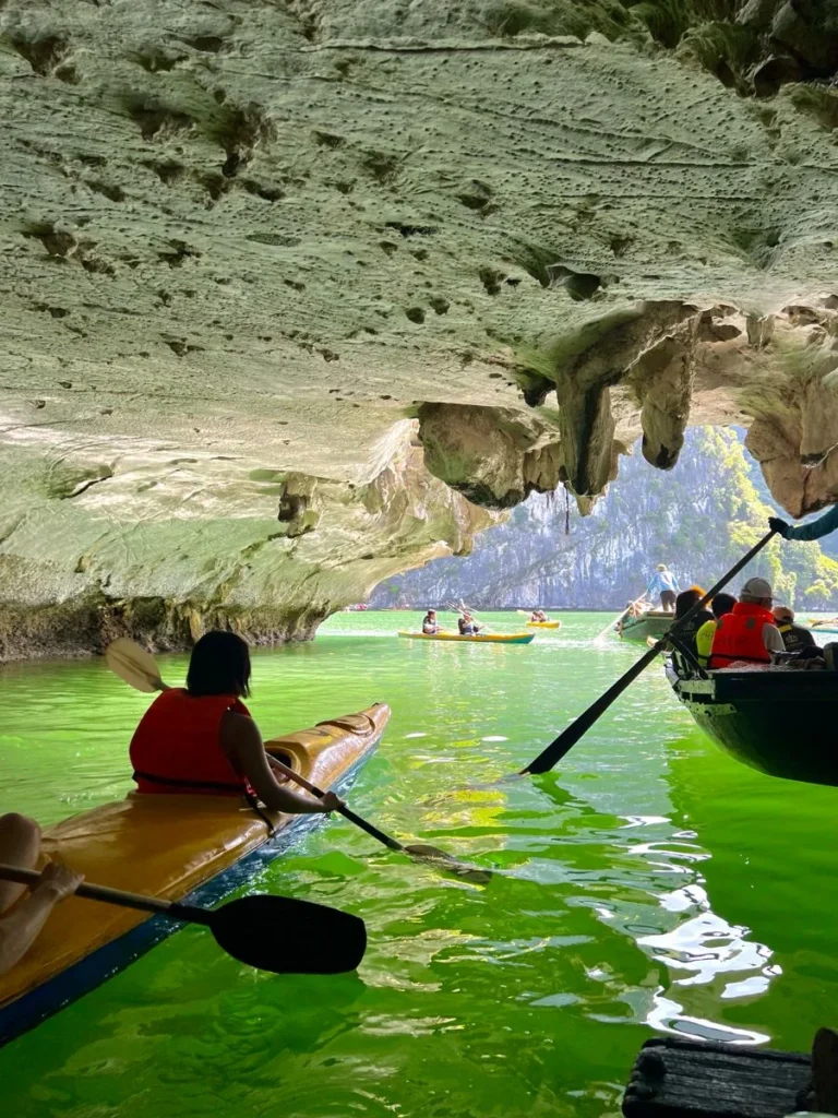 Du khách chèo kayak dưới vòm hang đá trên vịnh Hạ Long