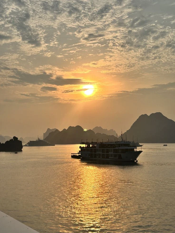 Hoàng hôn trên vịnh Hạ Long, tàu du lịch giữa mặt nước vàng óng
