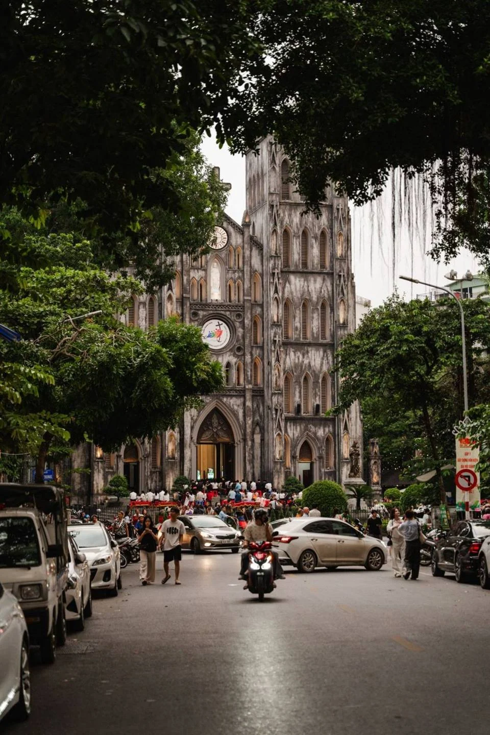 Nhà thờ Lớn Hà Nội kiến trúc gothic mái đá xám, nhìn qua hàng cây xanh trên phố Nhà Chung