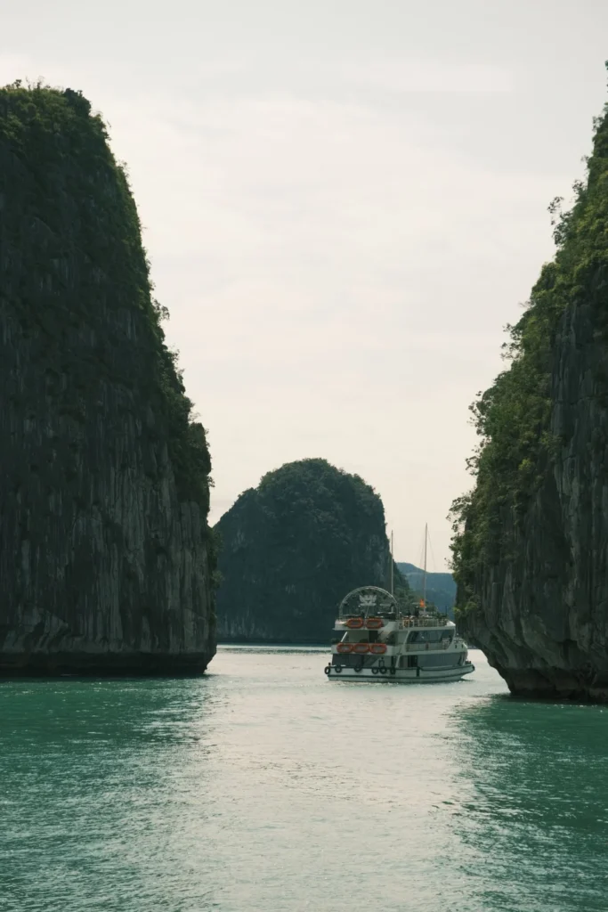 Tàu du lịch đi giữa hai vách núi đá vôi trên vịnh Hạ Long